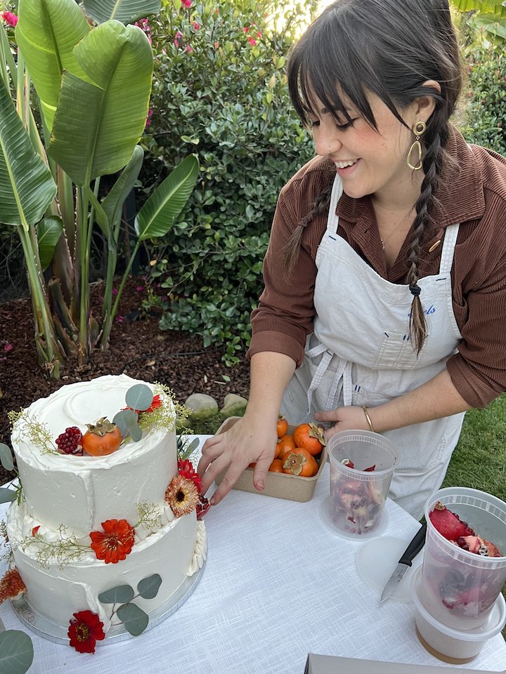 Pastry Chef & Partner Kelsey Brito decorating a wedding cake