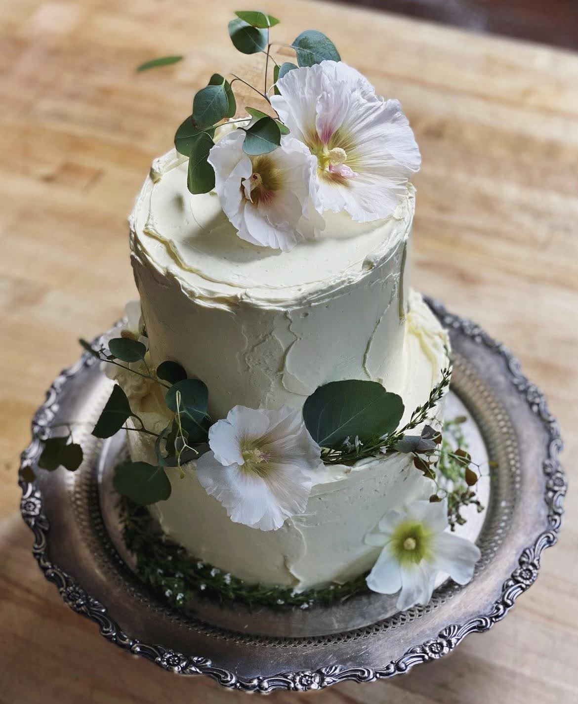 A two-tier wedding cake decorated with white flowers